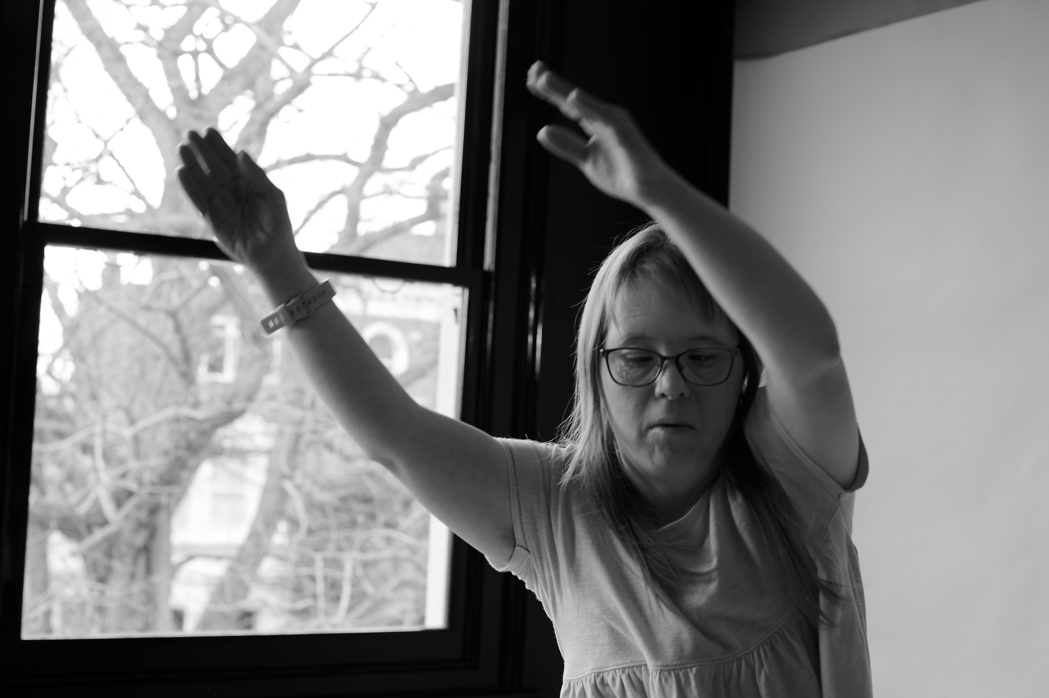 Black and white photo of a woman dancing with her arms raised